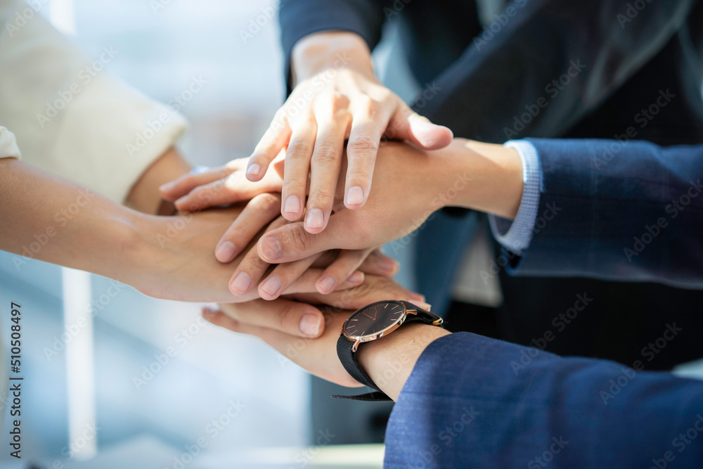 Business partners teamwork or friendship concept. Multiethnic diverse group of colleagues join hands together Business partners teamwork or friendship concept. Multiethnic diverse group of colleagues join hands together