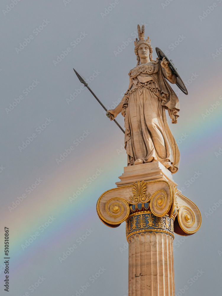 A rainbow over Athena statue, the ancient Greek goddess of wisdom on an Ionic style column at the national academy of Athens, Greece. A rainbow over Athena statue, the ancient Greek goddess of wisdom on an Ionic style column at the national academy of Athens, Greece.