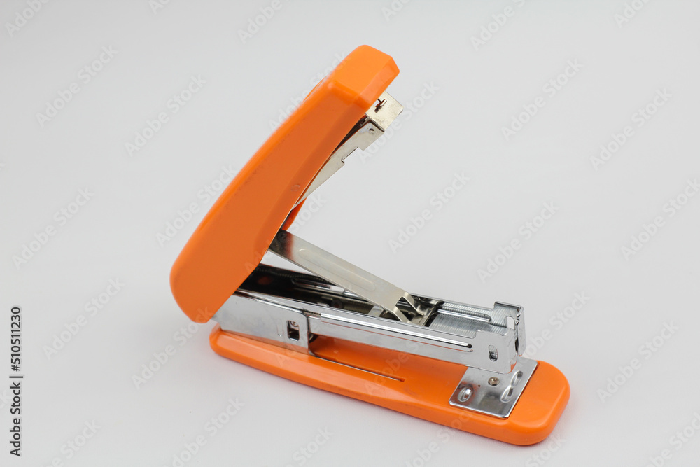 orange big stapler on white background in studio orange big stapler on white background in studio
