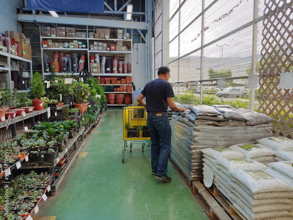 man with a wheelbarrow in a garden supplies shop