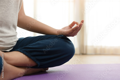 Woman in yoga post gesture at home on sunny day 