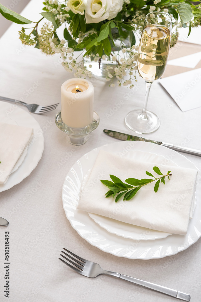 Wedding teble decoration with white flowers, glasses and white napkins. Elegantly decorated table at a wedding reception. Festive table setting. The wedding decor. Wedding teble decoration with white flowers, glasses and white napkins. Elegantly decorated table at a wedding reception. Festive table setting. The wedding decor.