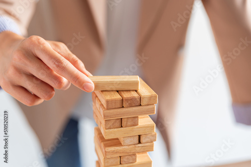 business female hand building a wooden block tower, risk and strategy of project management , business and strategy concept