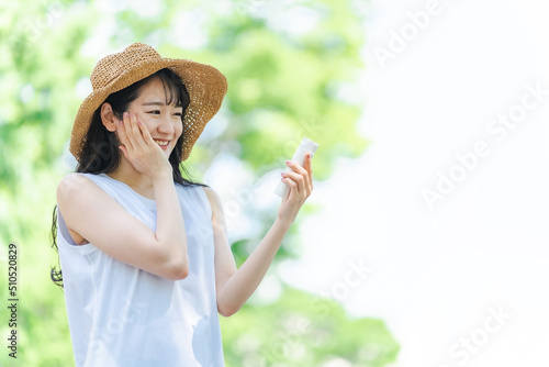 夏のスキンケアをする女性（日焼け止め・UVケア） 