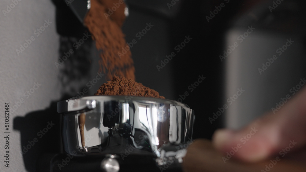 grinding coffee beans in portafilter closeup