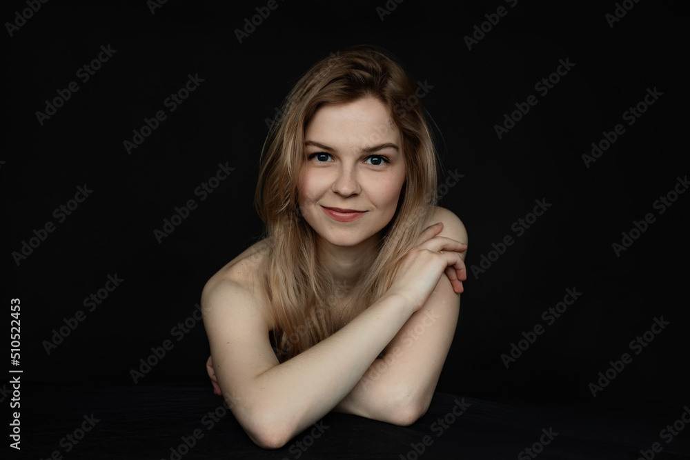 Portrait closeup of smiling attractive lady with perfect makeup in closed position with crossing bare arms on black background. Fashion studio shooting of elegant woman with professional lighting Portrait closeup of smiling attractive lady with perfect makeup in closed position with crossing bare arms on black background. Fashion studio shooting of elegant woman with professional lighting
