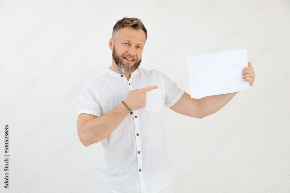Bearded smiling businessman demonstrating empty blank sheet paper. Mock up, place for text. Promotion career. Copy space Bearded smiling businessman demonstrating empty blank sheet paper. Mock up, place for text. Promotion career. Copy space