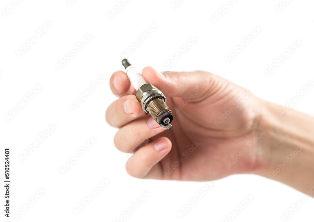 The hand holds an old iridium spark plug. Close up. Isolated on a white background The hand holds an old iridium spark plug. Close up. Isolated on a white background
