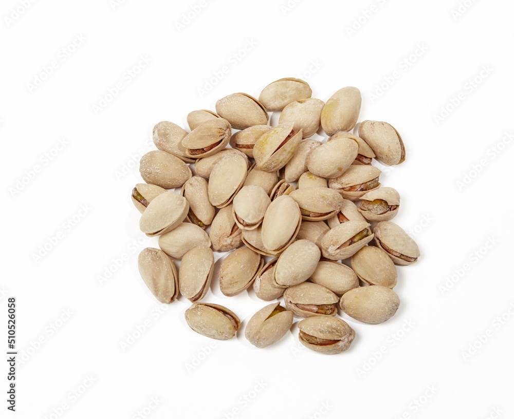 Pile of pistachios isolated on white background. Closeup of pistachios in the peel
