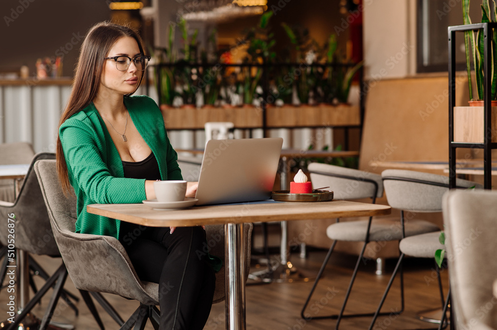 Sexy female blogger or freelancer is working with a laptop in the cafe or coworking area Sexy female blogger or freelancer is working with a laptop in the cafe or coworking area