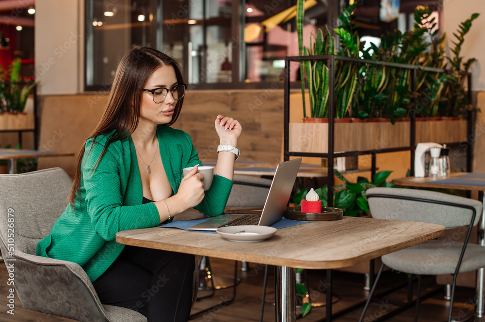 Sexy female blogger or freelancer is working with a laptop in the cafe or coworking area Sexy female blogger or freelancer is working with a laptop in the cafe or coworking area