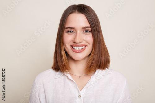 Portrait of smiling cheerful woman wearing shirt posing isolated over white background, looking at camera with toothy smile, expressing happiness and positive expression.