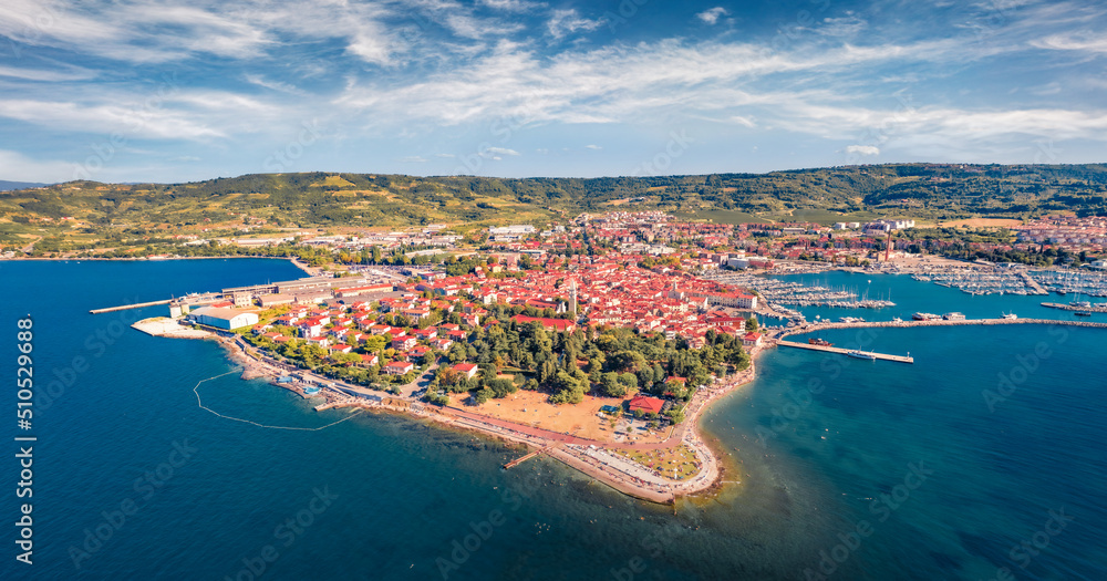 Attractive morning cityscape of Izola town, Slovenia, Europe. Breathtaking summer seascape of Adriatic sea. View from flying drone of old sea port. Traveling concept background.