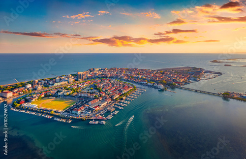 Incredible summer sunset in Grado port, small town located between Venice and Trieste. Attractive evening seascape of Adriatic sea. Traveling concept background. photo