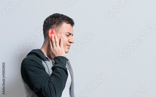 A person with otitis and tinnitus, Person with ear pain, on isolated background, Suffering man massaging his ear isolated photo