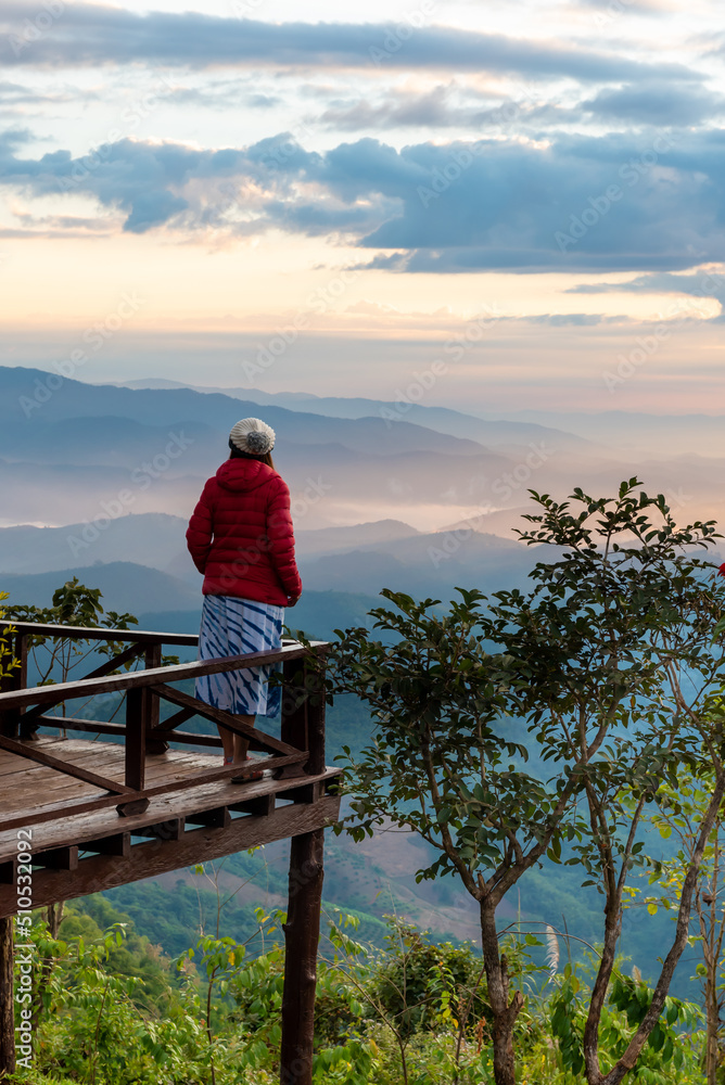 Traveler Asian woman enjoying and relaxing on the mountains view containing calm, fog, and mist in the morning.