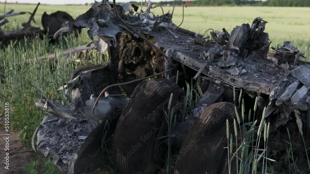 Downed military transport aircraft. Russian aggression in Ukraine. The remains of a burned-out aircraft on the field. Downed military transport aircraft. Russian aggression in Ukraine. The remains of a burned-out aircraft on the field.