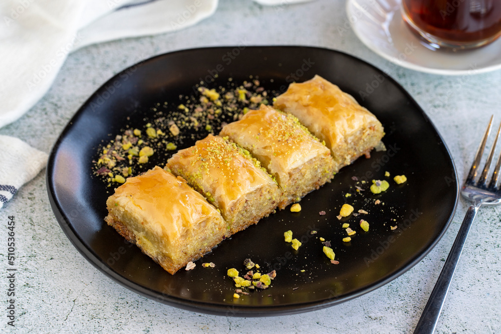 Pistachio baklava. Traditional Mediterranean cuisine delicacies. Baklava on stone background. Close-up. local name fistikli sarma baklava Pistachio baklava. Traditional Mediterranean cuisine delicacies. Baklava on stone background. Close-up. local name fistikli sarma baklava