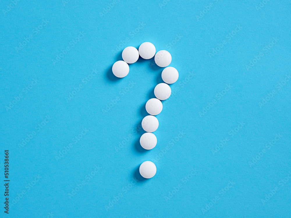 Question mark symbol made of medical pills on blue background. Medical side effect of drugs concept. Question mark symbol made of medical pills on blue background. Medical side effect of drugs concept.