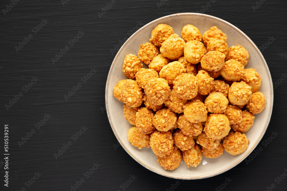 Homemade Crumbly Biscuits with Parmigiano Reggiano on a Plate on a black background, top view. Flat lay, overhead, from above. Homemade Crumbly Biscuits with Parmigiano Reggiano on a Plate on a black background, top view. Flat lay, overhead, from above.
