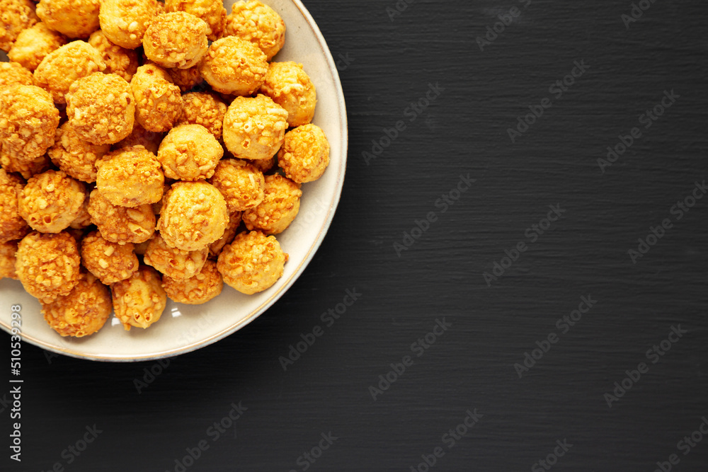Homemade Crumbly Biscuits with Parmigiano Reggiano on a Plate on a black surface, top view. Flat lay, overhead, from above. Copy space. Homemade Crumbly Biscuits with Parmigiano Reggiano on a Plate on a black surface, top view. Flat lay, overhead, from above. Copy space.
