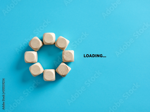 Wooden cubes with the word loading in loading progress indicator bar. photo