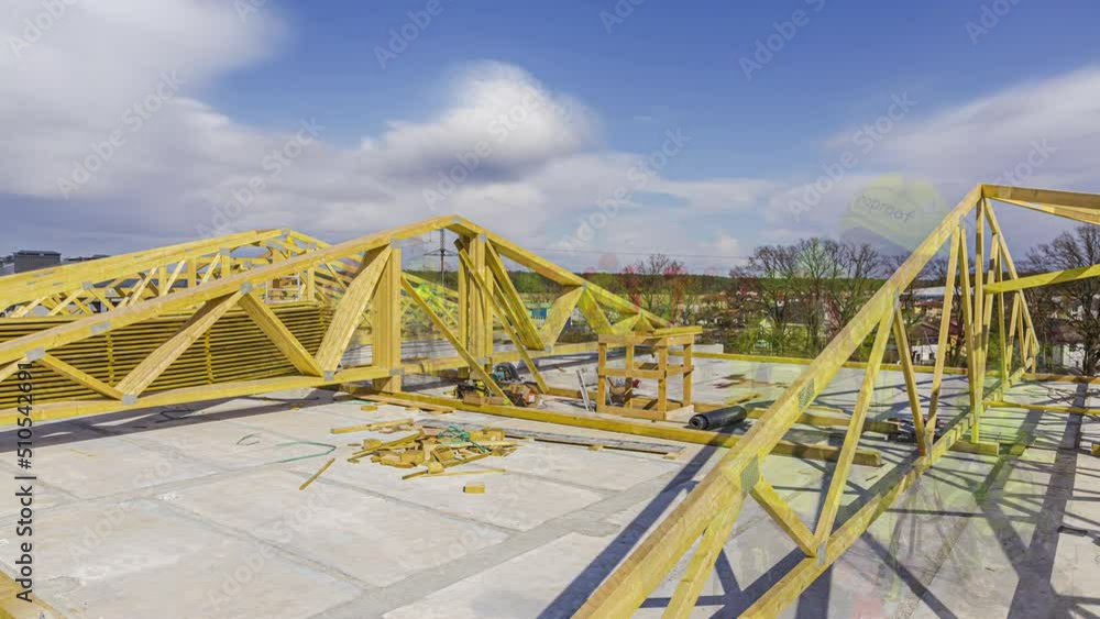 Timelapse shot of workers building interior of frame house roof under construction with white clouds passing by. Timelapse shot of workers building interior of frame house roof under construction with white clouds passing by.