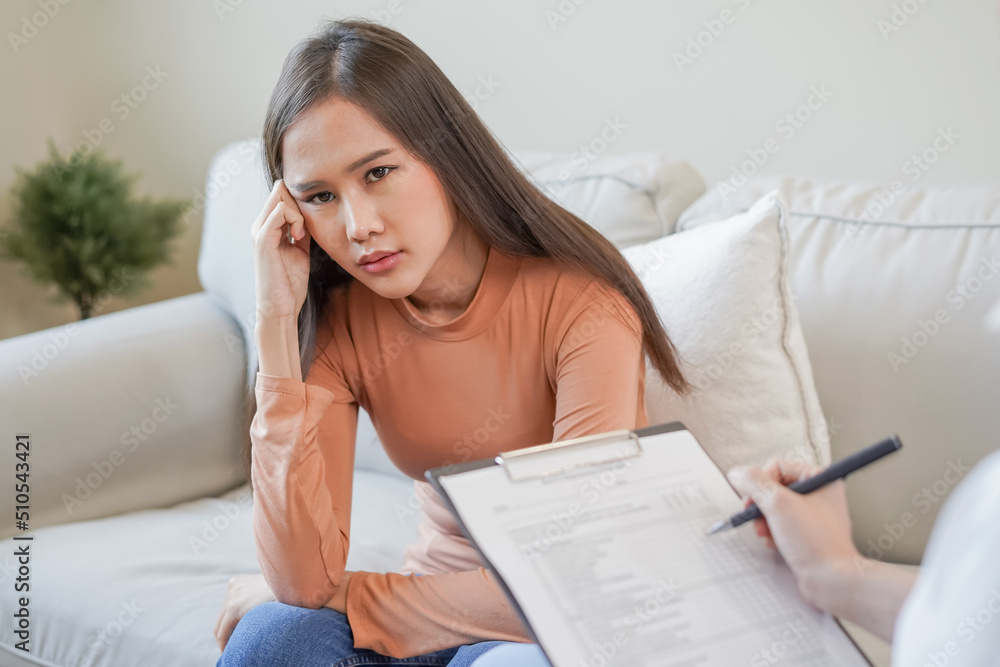 Psychology, depression. Sad, suffering asian young woman consulting with psychologist, psychiatrist while patient counseling mental with doctor woman taking notes at clinic. Encouraging, therapy. Psychology, depression. Sad, suffering asian young woman consulting with psychologist, psychiatrist while patient counseling mental with doctor woman taking notes at clinic. Encouraging, therapy.