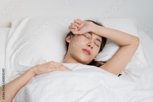Sweet dreams, attractive smile pretty asian young woman, girl sleeping in comfortable bed lying on soft pillow resting, keeping eyes closed while with covered blanket in cozy white bed in the morning.