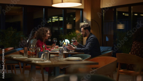 Fototapeta Naklejka Na Ścianę i Meble -  Happy couple drinking wine glass in fancy restaurant table. Romantic concept.