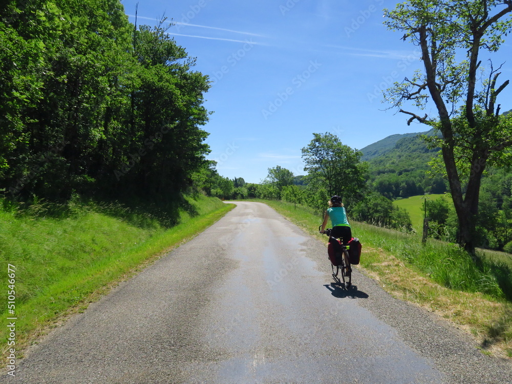 Jeune femme à vélo et bicyclette avec sacoche en cyclotourisme sur les pistes cyclables et voies vertes du sud de la France région Occitanie montagne Noire Lacaune Espinouse 