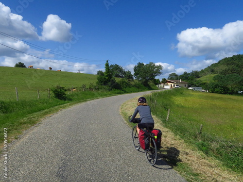 Jeune femme à vélo et bicyclette avec sacoche en cyclotourisme sur les pistes cyclables et voies vertes du sud de la France région Occitanie montagne Noire Lacaune Espinouse  © Ourson+