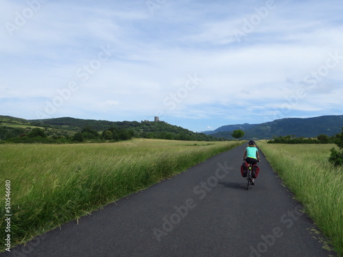 Jeune femme à vélo et bicyclette avec sacoche en cyclotourisme sur les pistes cyclables et voies vertes du sud de la France région Occitanie montagne Noire Lacaune Espinouse 