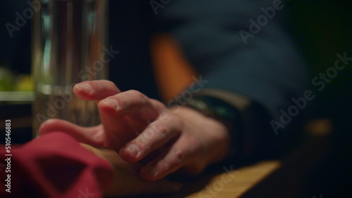 Supporting couple holding hands on romantic dinner date at restaurant table.