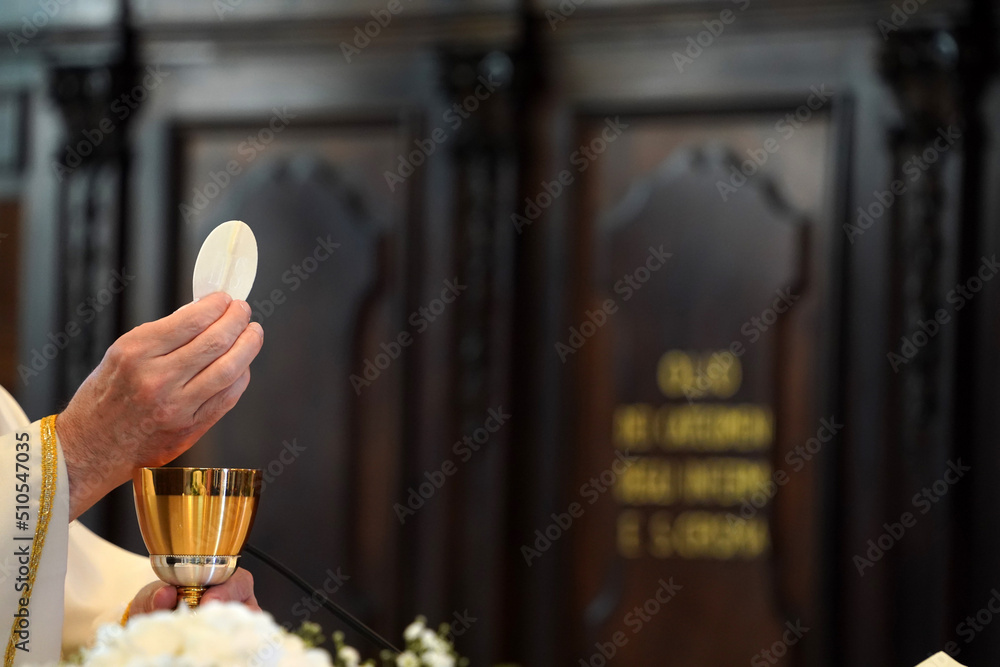 Priest showing the host during the mass - obrazy, fototapety, plakaty 