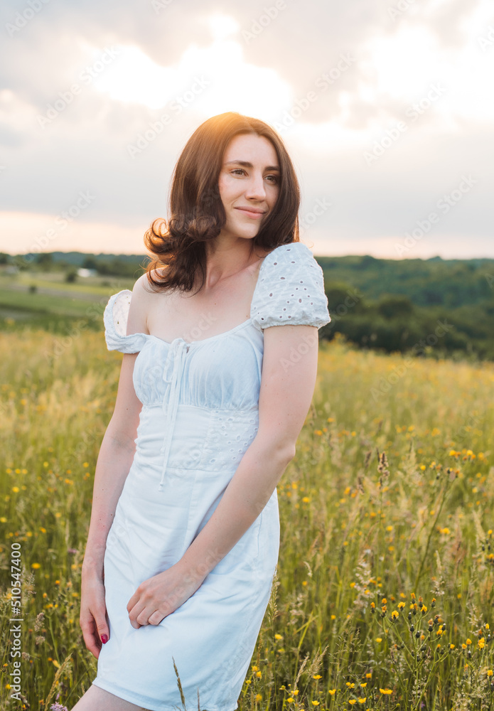 young happy female walking in the field enjoying beautiful sunset. Beautiful countryside. Slow living concept young happy female walking in the field enjoying beautiful sunset. Beautiful countryside. Slow living concept