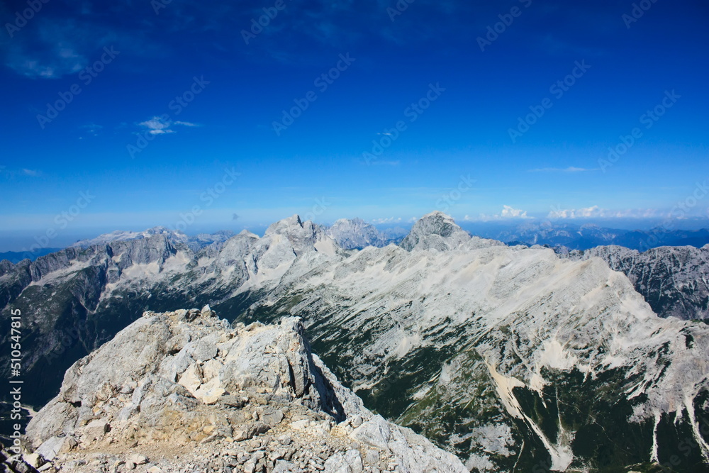 Landscape image of the western Julian Alps on the border between Italy and Slovenia. The mountains in the picture are Jalovec, Jof di Montasio (background) and Mangart.