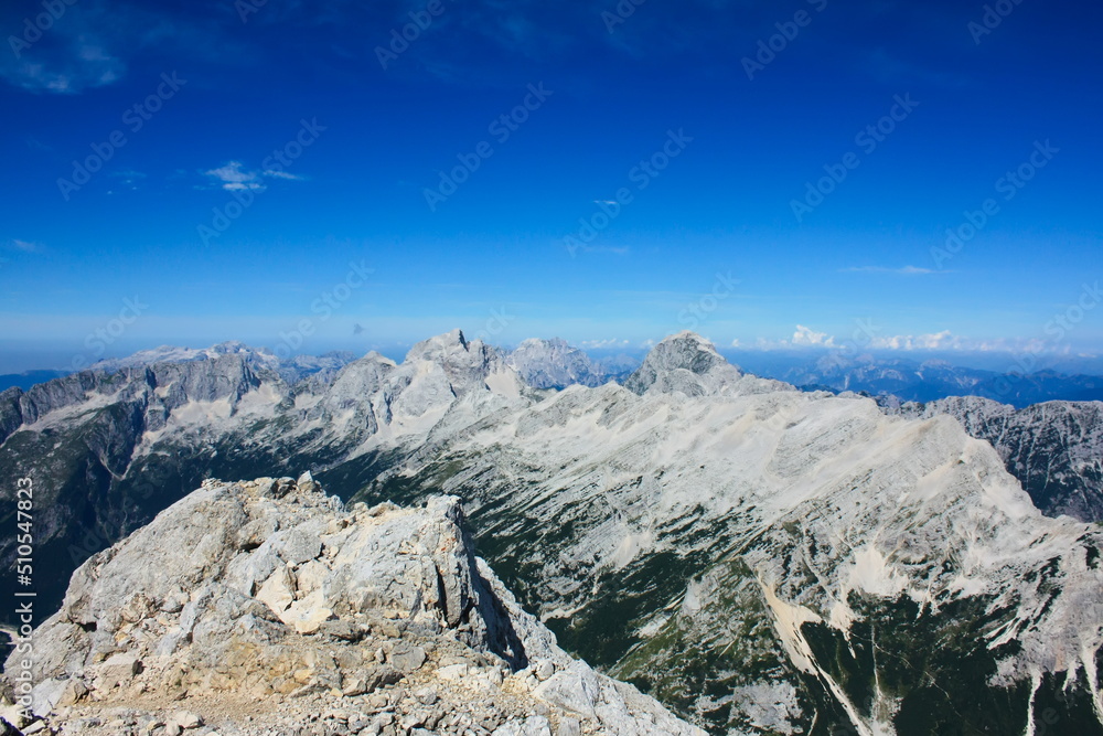 Landscape image of mountains in the Slovenian Julian Alps and western Julian alps in Italy. The main peaks in the image are from left to right Jalovec, Jof di Montasio and Mangart.