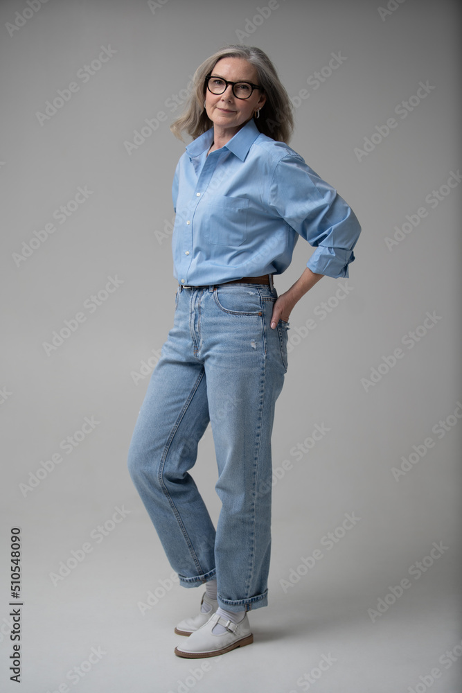 Full length shot of a elegant mid adult woman. Stylish mature woman in blue casuals looking at camera and smiling Full length shot of a elegant mid adult woman. Stylish mature woman in blue casuals looking at camera and smiling