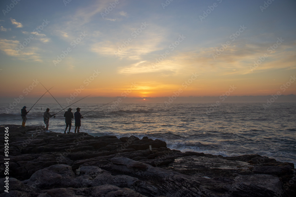 Silhouette of people catching fish on the south coast of South Africa in Margate