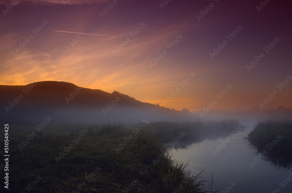 Fog at dawn near the river under the mountain
