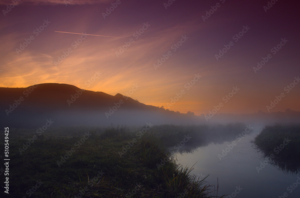 Fog at dawn near the river under the mountain Fog at dawn near the river under the mountain