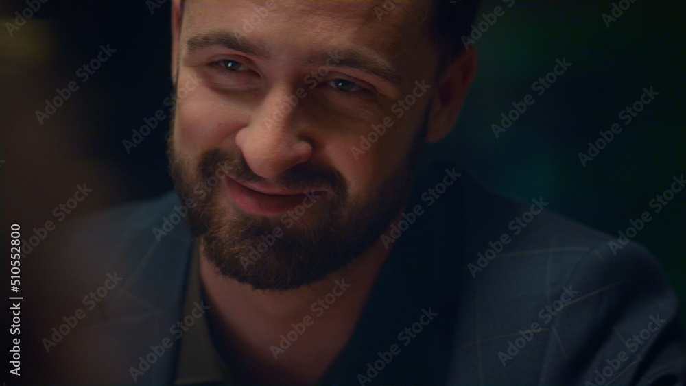 Obraz premium Happy man talking smiling in romantic light restaurant. Date chatting concept.