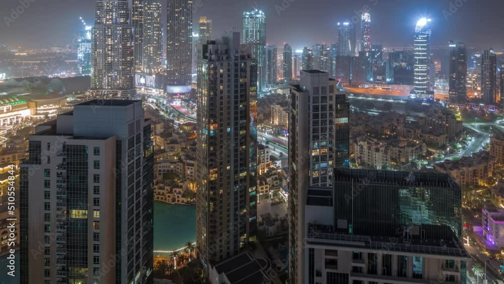 Aerial panoramic view of futuristic city during all night timelapse. Business bay and Downtown district with lights turning off in skyscrapers and traditional houses, Dubai, United Arab Emirates Aerial panoramic view of futuristic city during all night timelapse. Business bay and Downtown district with lights turning off in skyscrapers and traditional houses, Dubai, United Arab Emirates
