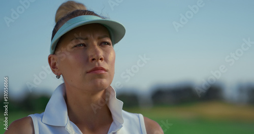Successful woman play golf at course. Beautiful golfer face looking away outside