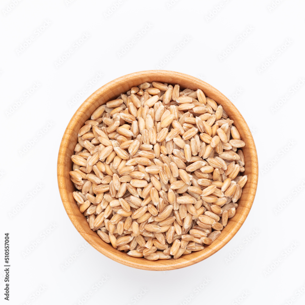 Wheat grains and wooden bowl on white background.