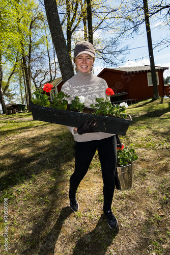 Photography Stockholm, Sweden  A woman member of a community run boat club volunteers for jobs in the spring on the grounds of the boat club like planting flowers