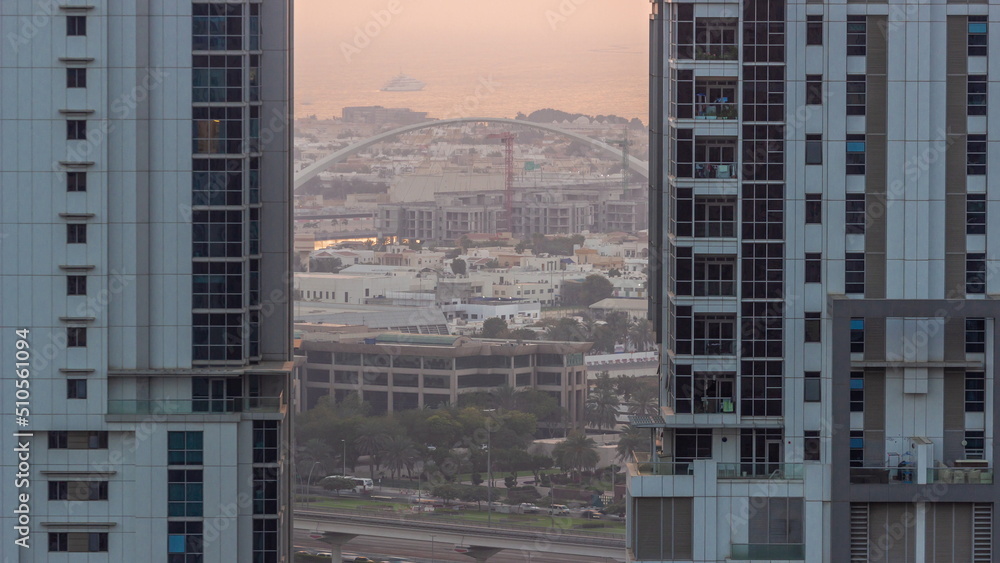 Fototapeta premium The second pedestrian bridge of Dubai water canal suspended by an oval arch aerial timelapse from Business bay district.