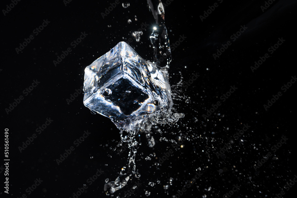 ice cube in water jet on black background ice cube in water jet on black background