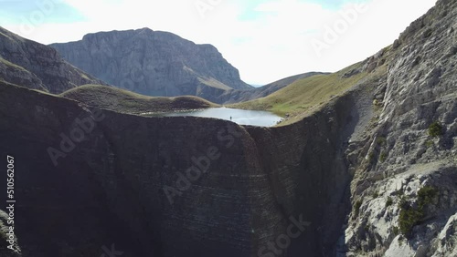 Wallpaper Mural Aerial drone video from iconic and beautiful lake Drakolimni of Tymfi mountain, man stay on edge of cliff, Vikos National Park, Zagori, Greece Torontodigital.ca